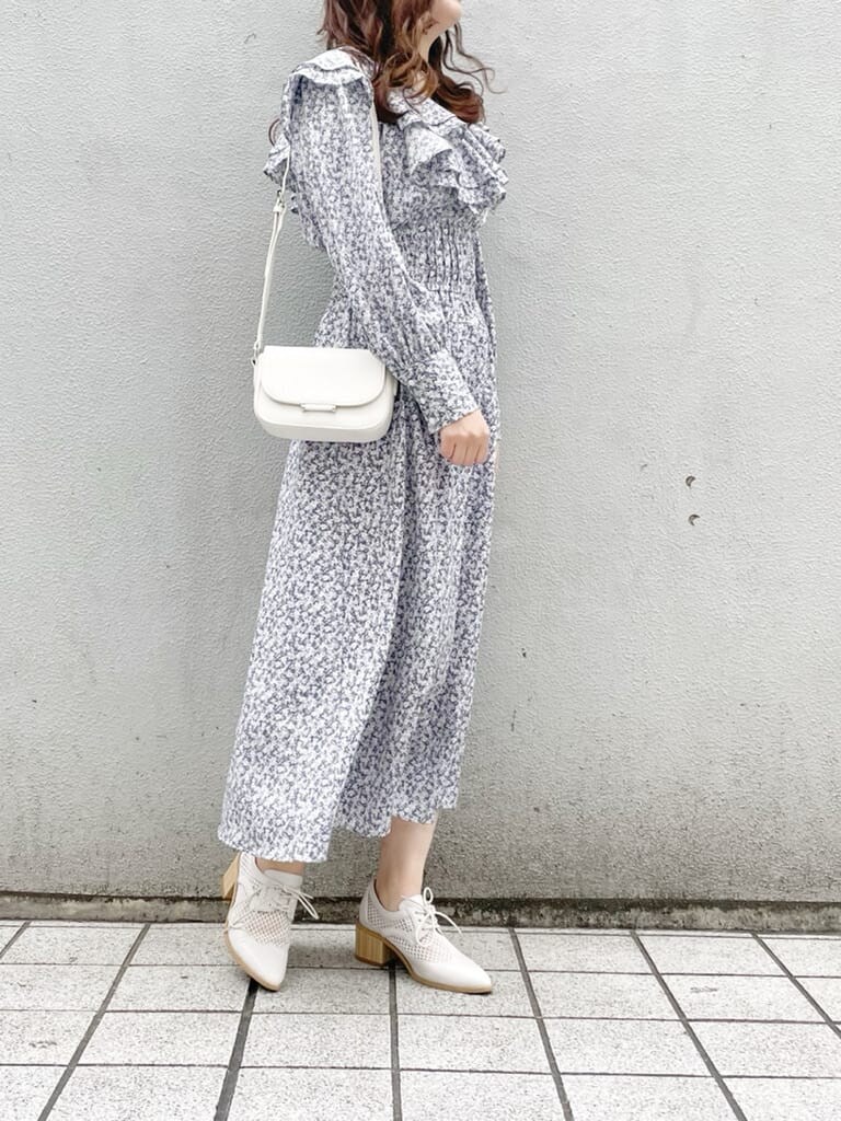 ブルー系のワンピース、ホワイト系のローファー、ホワイト系のショルダーバッグを着用したレディースの冬コーディネートの3枚目の写真