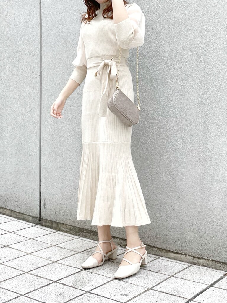 ベージュ系のワンピース、ホワイト系のパンプス、ベージュ系のショルダーバッグを着用したレディースの冬コーディネートの2枚目の写真