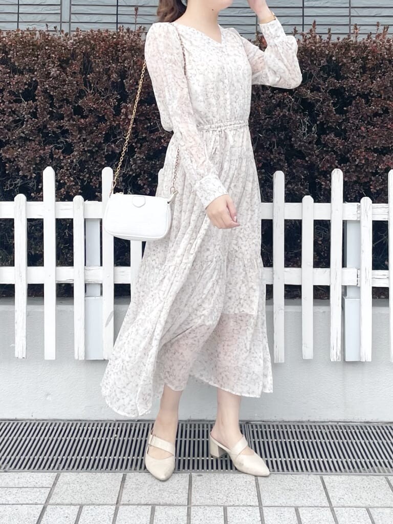 ベージュ系のテーラードジャケット、ホワイト系のパンプス、オレンジ系のワンピースを着用したレディースの冬コーディネートの4枚目の写真