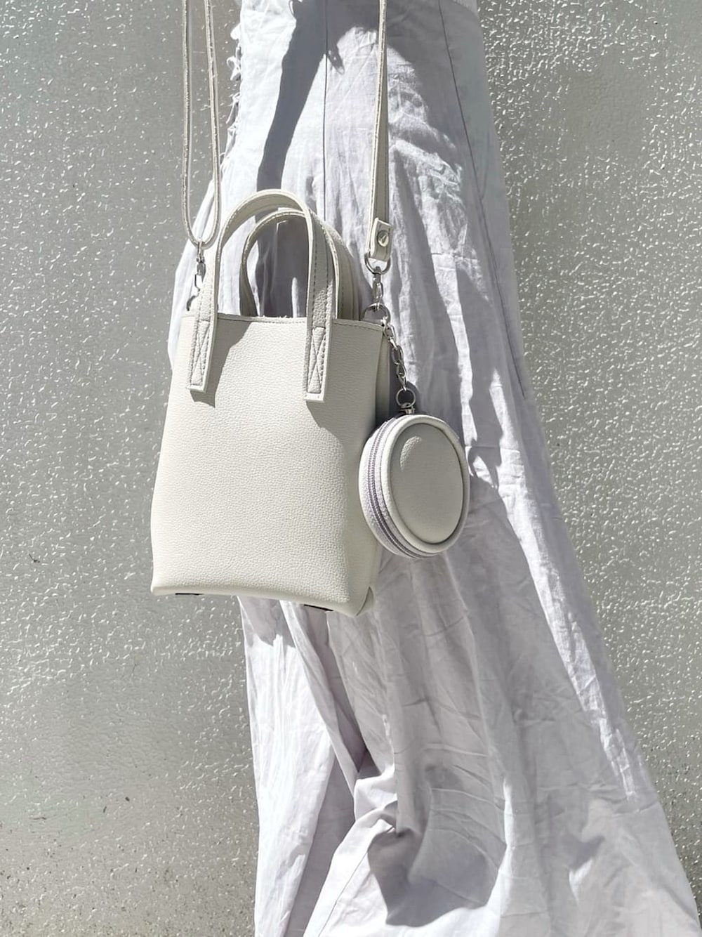 グレー系のハンドバッグ、ホワイト系のシャツ/ブラウス、グレー系のワンピースを着用したレディースの夏コーディネートの9枚目の写真