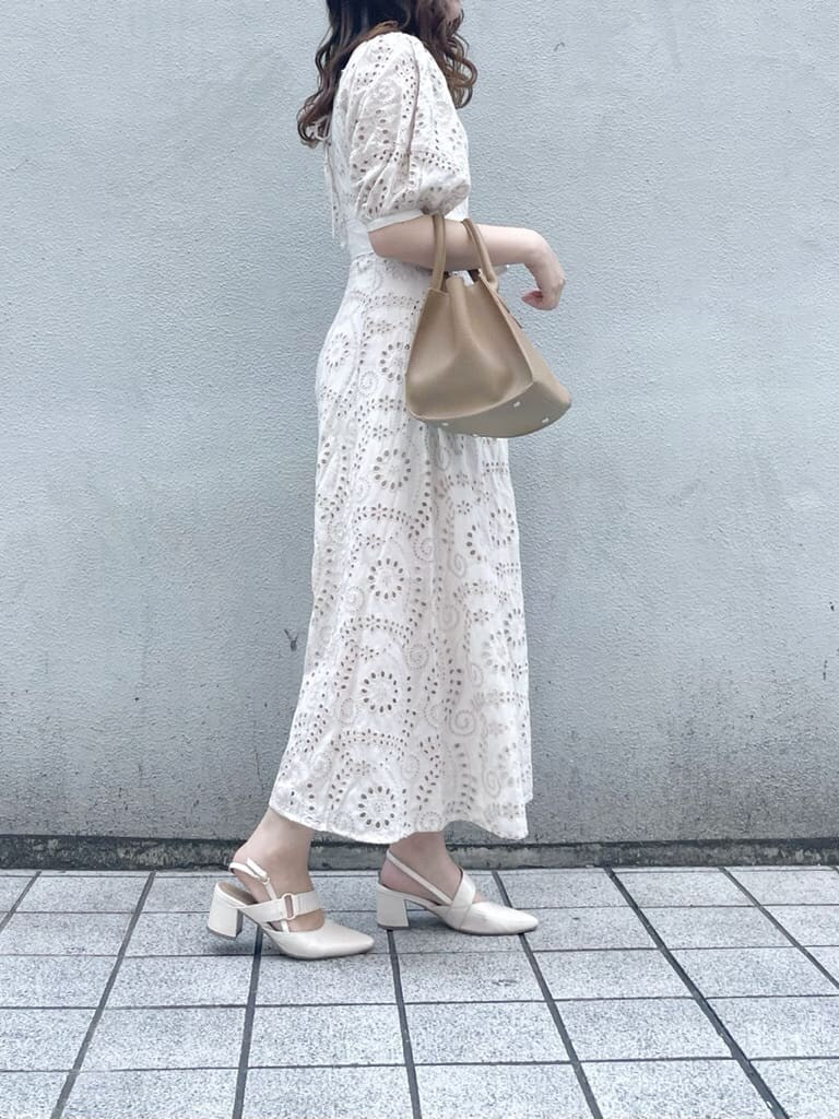 ホワイト系のワンピース、ベージュ系のハンドバッグ、ホワイト系のパンプスを着用したレディースの春コーディネートの3枚目の写真