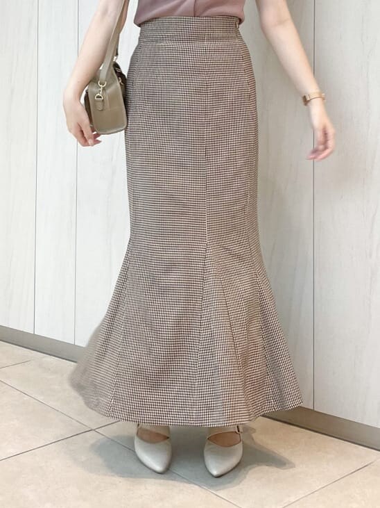 ブラウン系のスカート、ピンク系のニット/セーター、ベージュ系のハンドバッグを着用したレディースの秋コーディネートの3枚目の写真