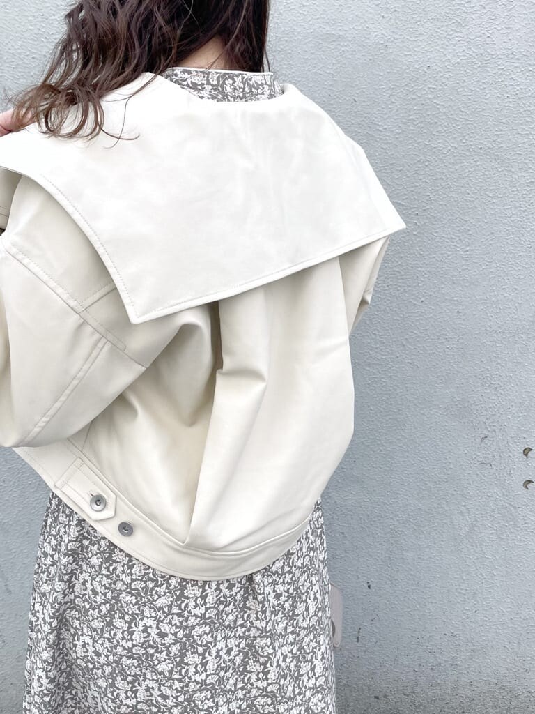 ホワイト系のワンピース、ホワイト系のライダースジャケット、ホワイト系のパンプスを着用したレディースの冬コーディネートの5枚目の写真