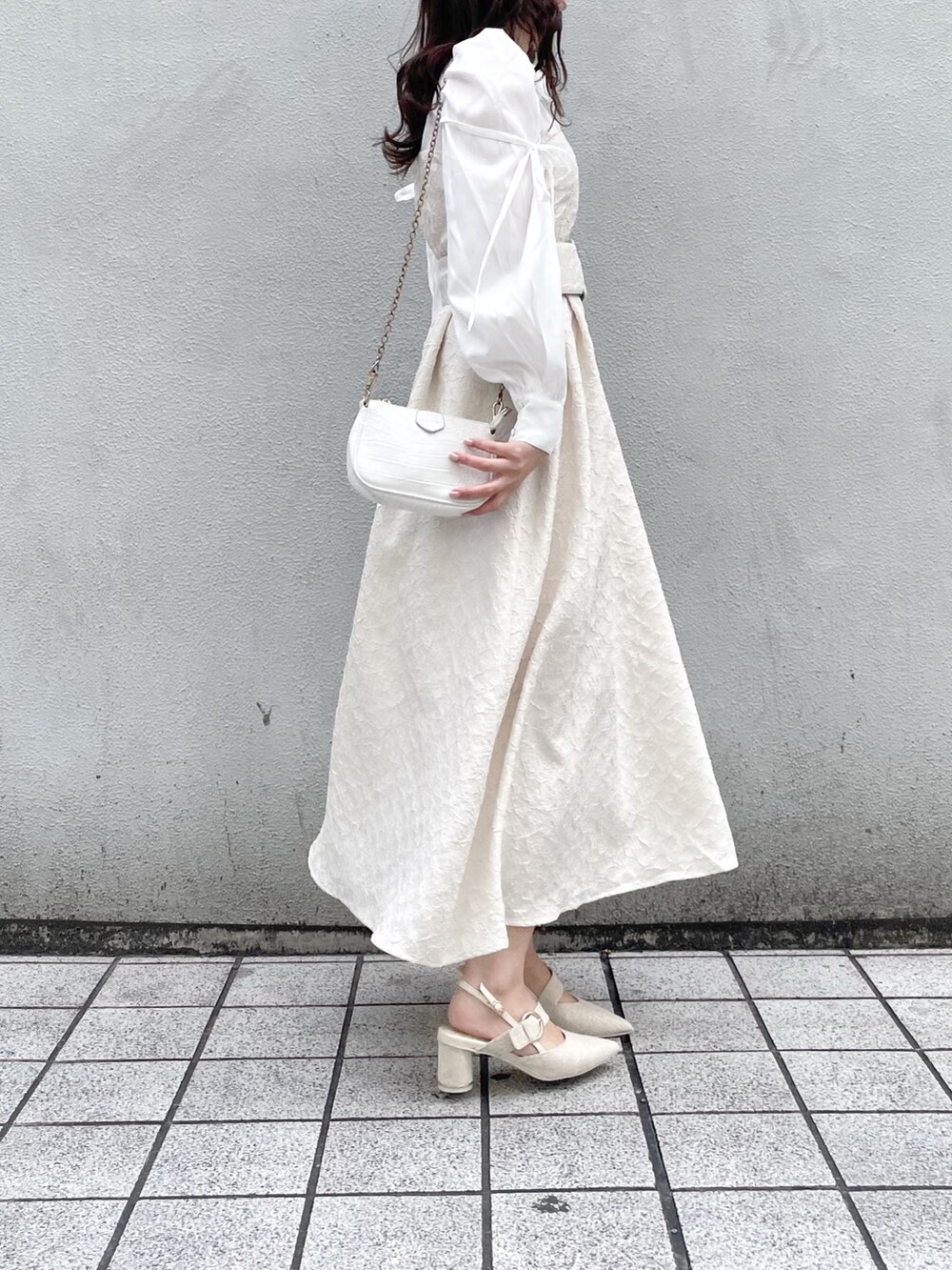 ホワイト系のワンピース、ホワイト系のパンプスを着用したレディースの冬コーディネートの3枚目の写真