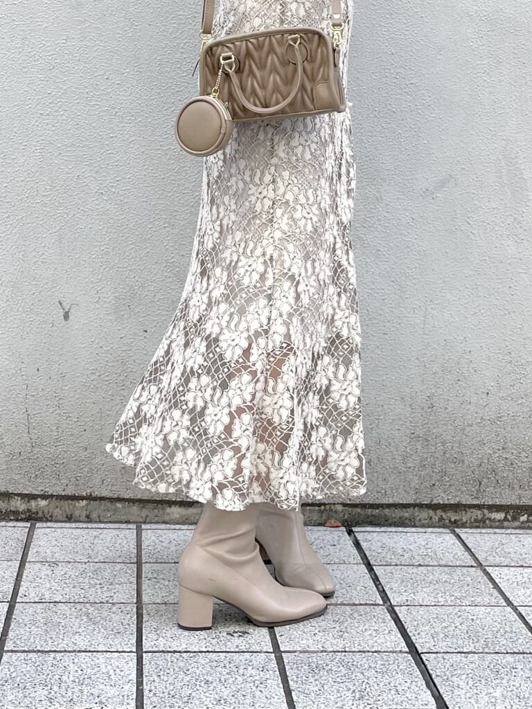 ベージュ系のスカート、ベージュ系のその他アウター、ベージュ系のハンドバッグを着用したレディースの秋コーディネートの7枚目の写真