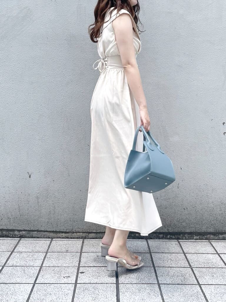 パープル系のサンダル、ブルー系のハンドバッグ、ホワイト系のワンピースを着用したレディースの夏コーディネートの2枚目の写真