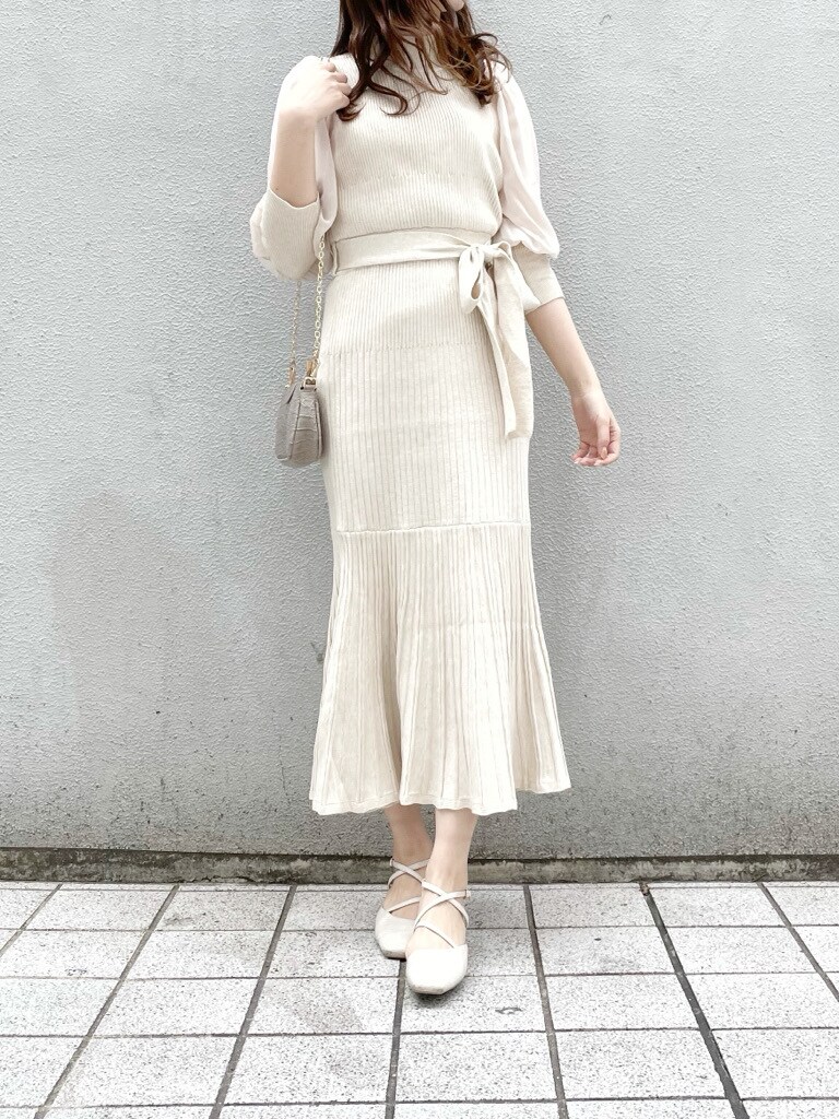 ベージュ系のワンピース、ホワイト系のパンプス、ベージュ系のショルダーバッグを着用したレディースの冬コーディネートの6枚目の写真