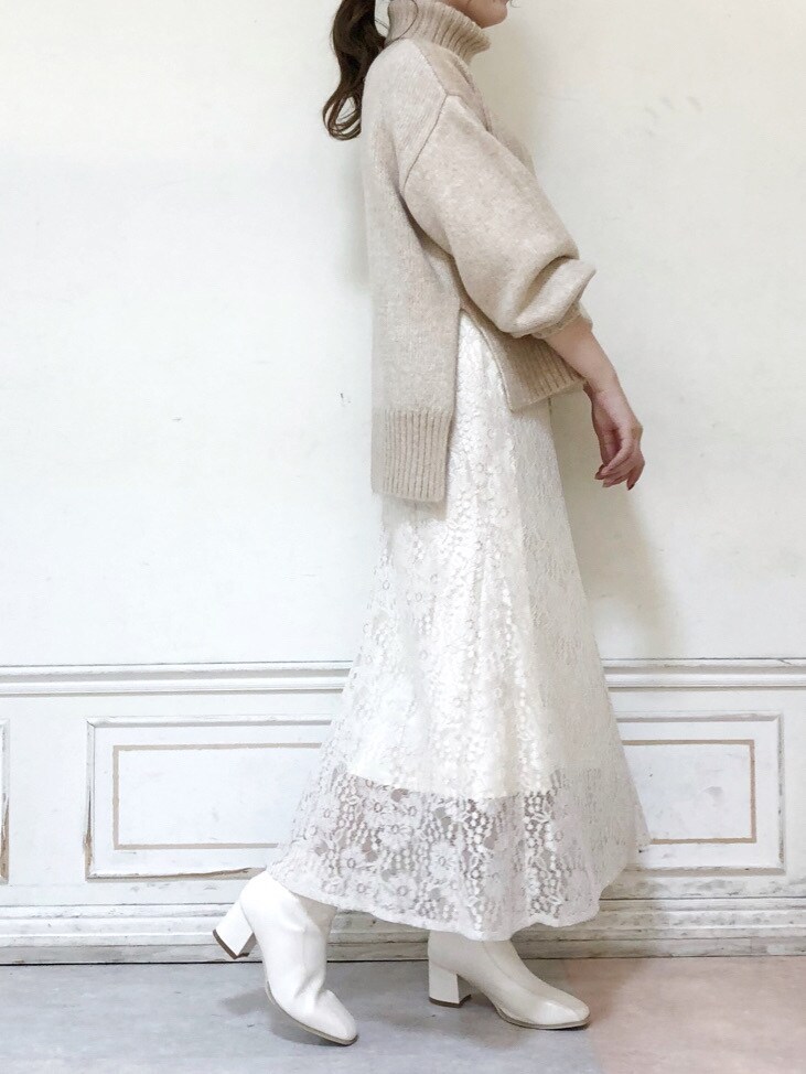 ホワイト系のブーツ、ベージュ系のニット/セーター、ホワイト系のスカートを着用したレディースの秋コーディネートの3枚目の写真