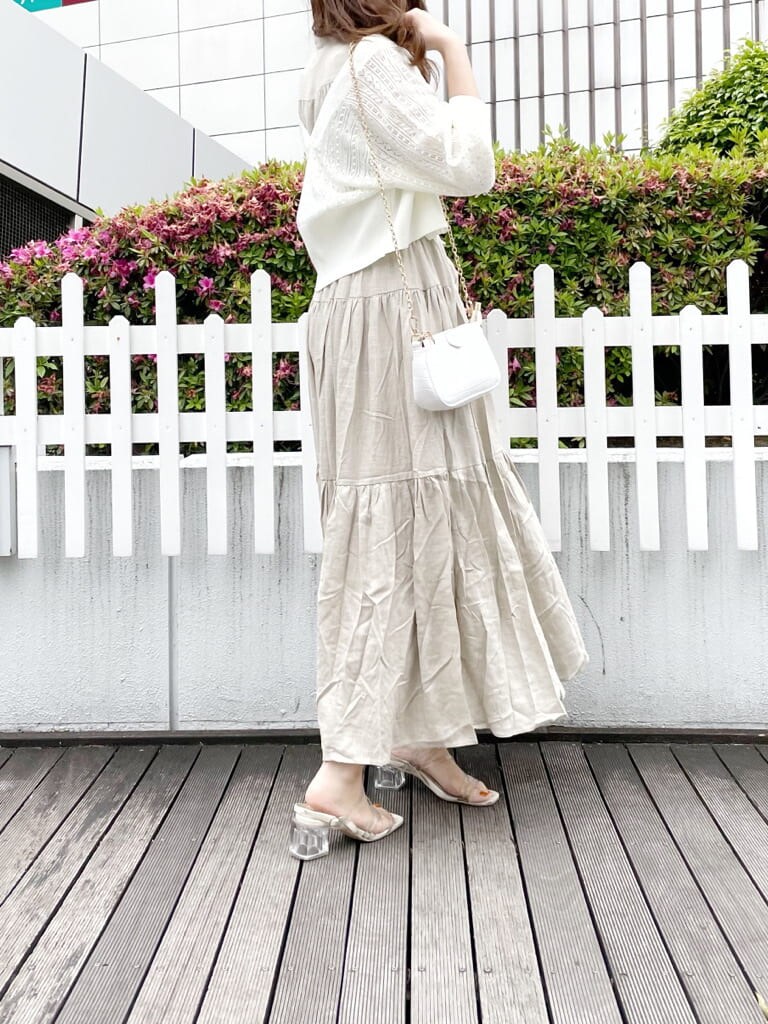 ベージュ系のワンピース、ホワイト系のショルダーバッグ、その他のサンダルを着用したレディースの夏コーディネートの2枚目の写真