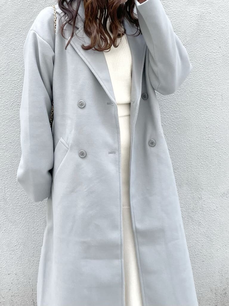 ベージュ系のブーツ、ホワイト系のワンピース、ブルー系のチェスターコートを着用したレディースの冬コーディネートの4枚目の写真