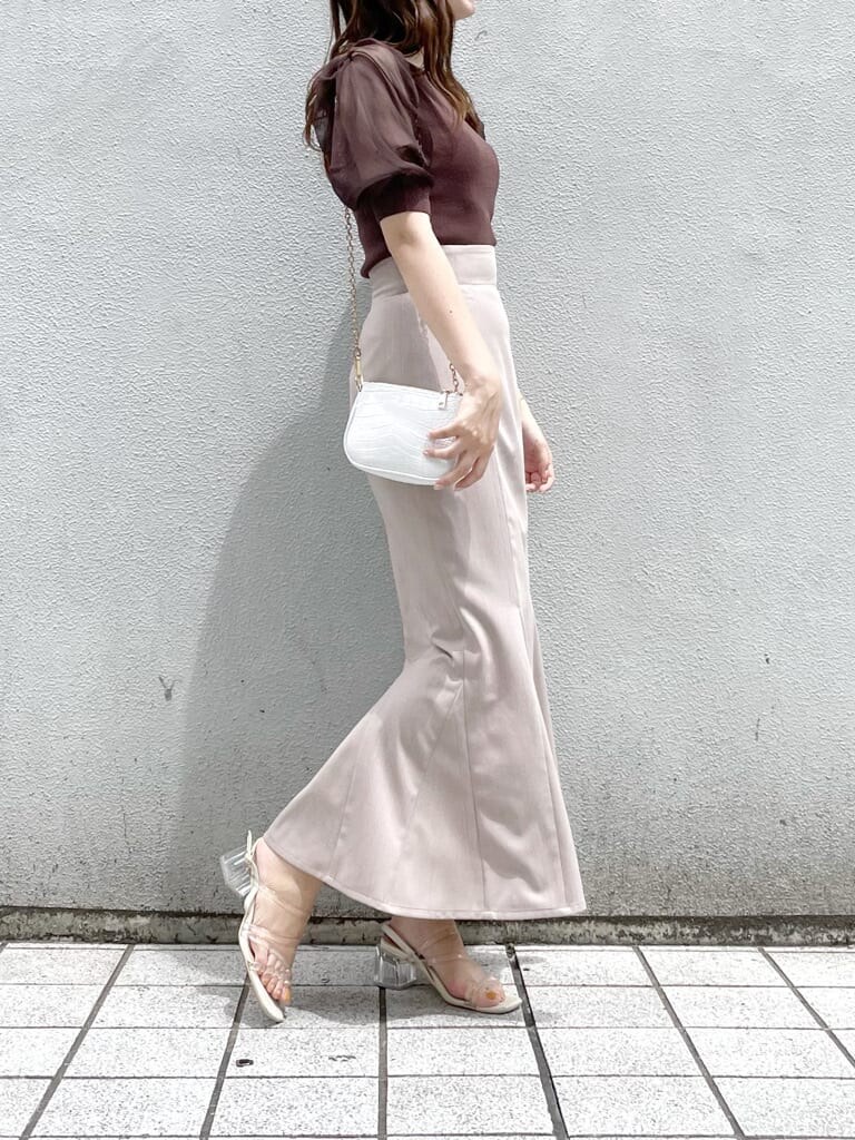 ホワイト系のショルダーバッグ、ブラウン系のスカート、その他のサンダルを着用したレディースの夏コーディネートの3枚目の写真