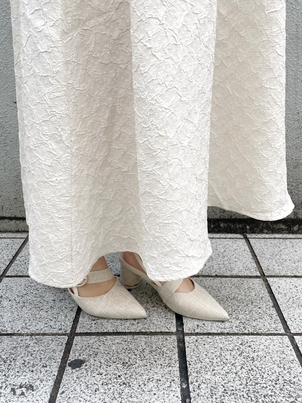 ホワイト系のワンピース、ホワイト系のパンプスを着用したレディースの冬コーディネートの8枚目の写真