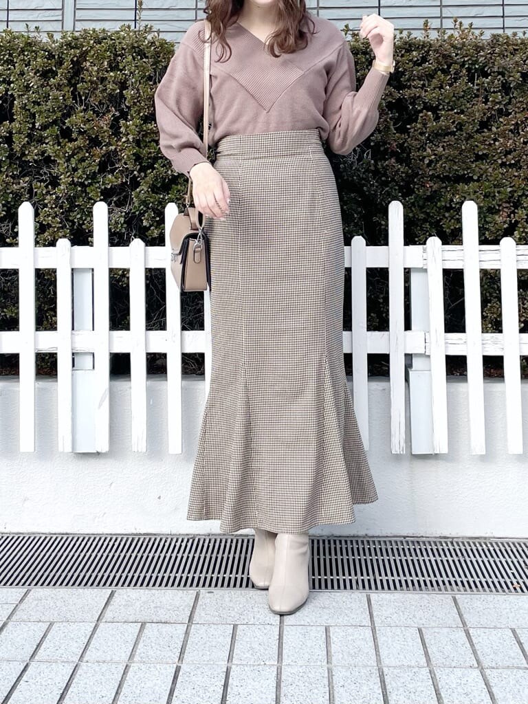 ベージュ系のブーツ、ブラウン系のニット/セーター、ブラウン系のスカートを着用したレディースの冬コーディネートの3枚目の写真