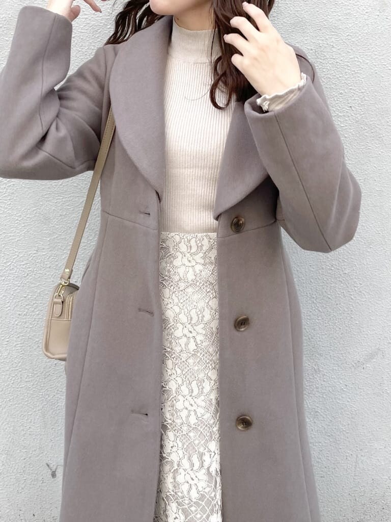 ベージュ系のスカート、ベージュ系のその他アウター、ベージュ系のハンドバッグを着用したレディースの秋コーディネートの3枚目の写真