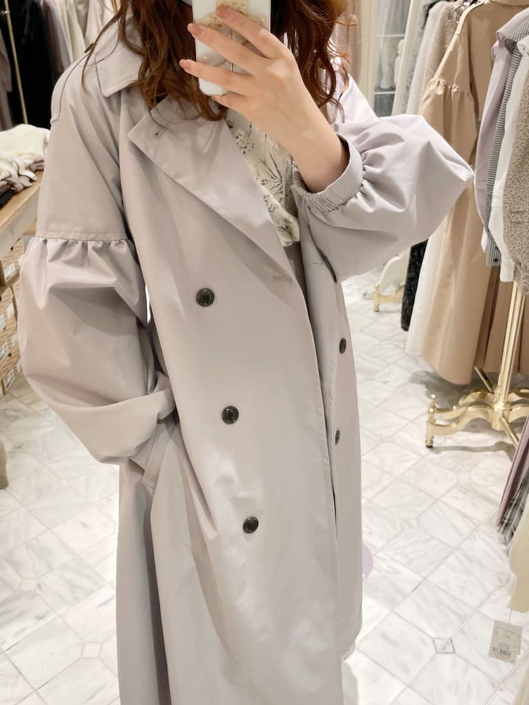 ベージュ系のブーツ、グレー系のトレンチコート、ホワイト系のワンピースを着用したレディースの冬コーディネートの4枚目の写真