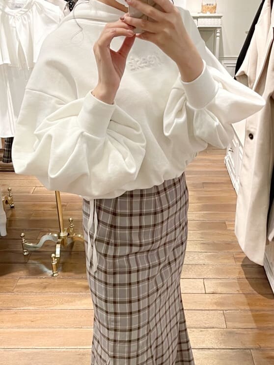 ホワイト系のその他シューズ、ホワイト系のパーカー、グレー系のスカートを着用したレディースの冬コーディネートの2枚目の写真