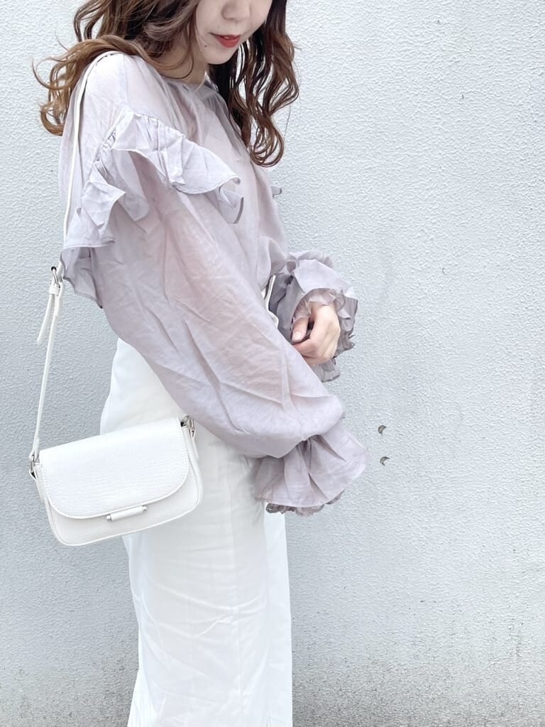 パープル系のシャツ/ブラウス、ホワイト系のパンプス、ホワイト系のショルダーバッグを着用したレディースの春コーディネートの7枚目の写真