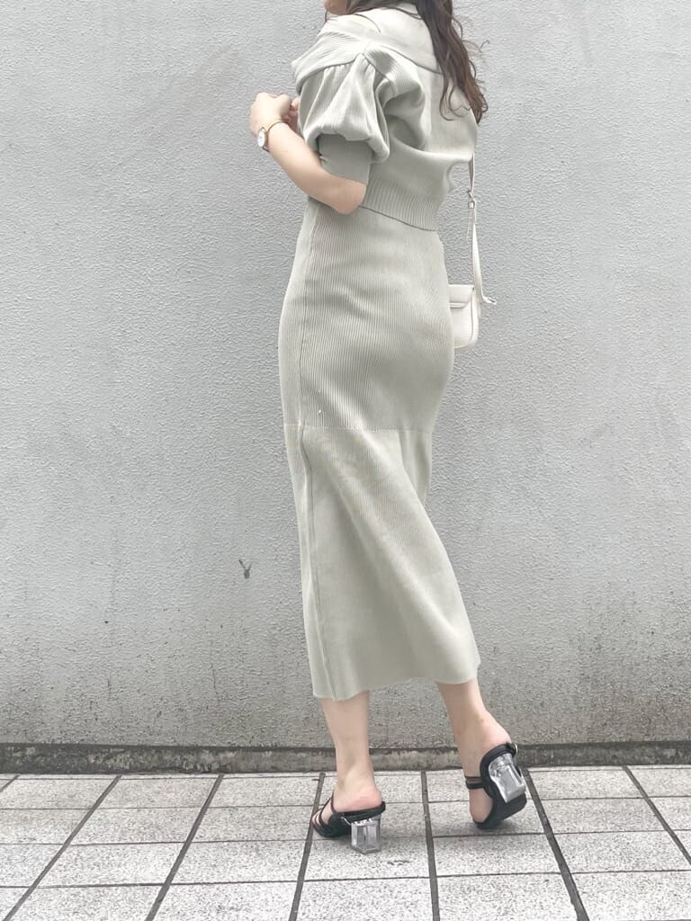 グリーン系のワンピース、ブラック系のサンダル、ホワイト系のショルダーバッグを着用したレディースの春コーディネートの2枚目の写真