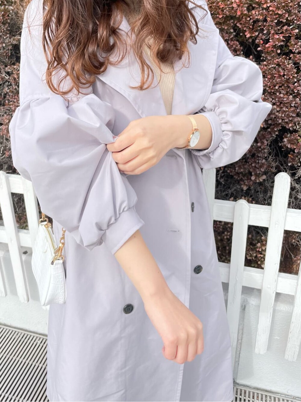 グレー系のトレンチコート、ホワイト系のワンピース、ホワイト系のパンプスを着用したレディースの春コーディネートの4枚目の写真