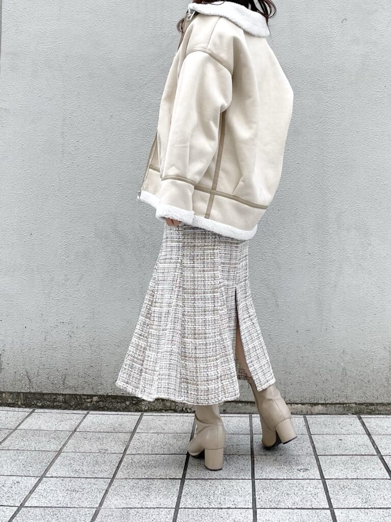 ホワイト系のブルゾン、ベージュ系のブーツ、ベージュ系のニット/セーターを着用したレディースの冬コーディネートの3枚目の写真