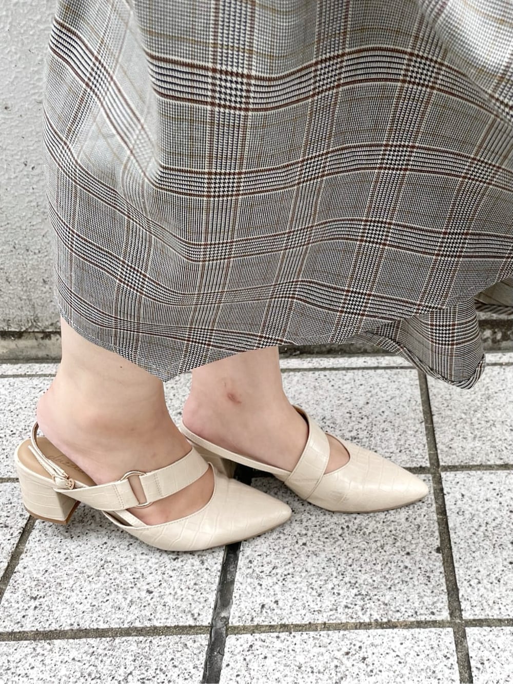 グレー系のワンピース、ホワイト系のニット/セーター、ホワイト系のパンプスを着用したレディースの秋コーディネートの9枚目の写真