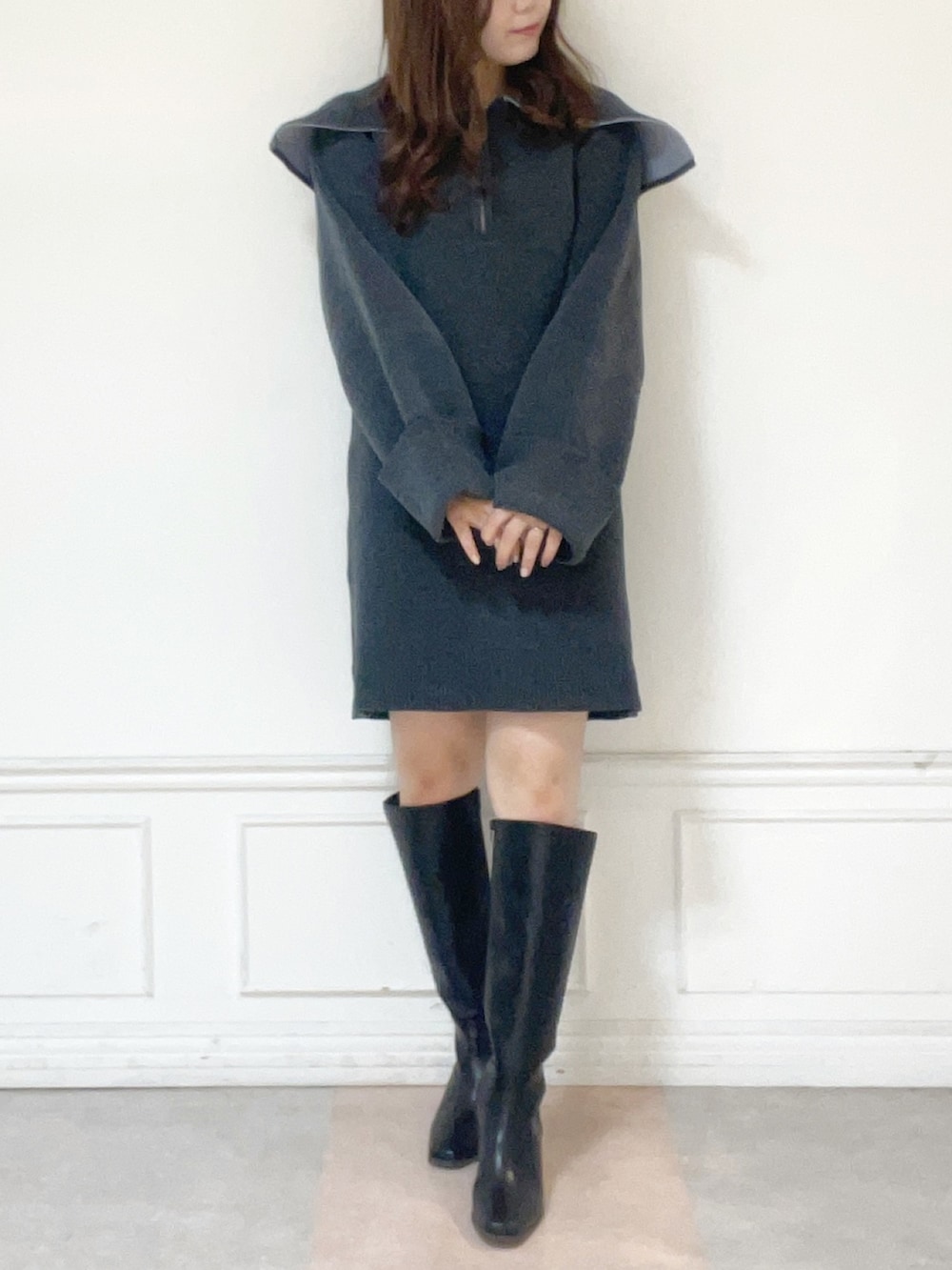 グレー系のワンピース、ブラック系のブーツを着用したレディースの秋コーディネートの2枚目の写真