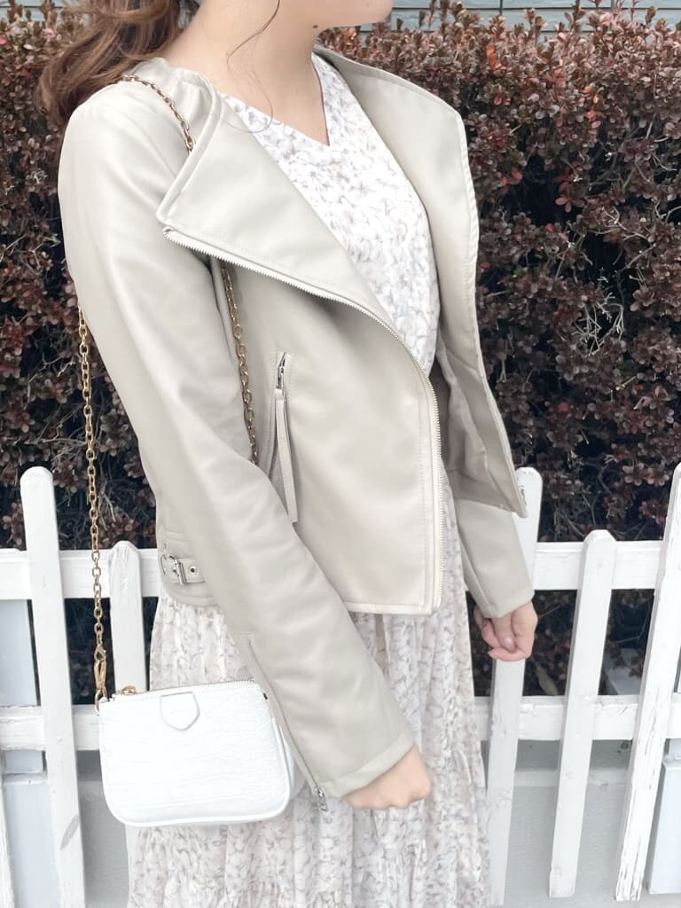 ベージュ系のテーラードジャケット、ホワイト系のパンプス、オレンジ系のワンピースを着用したレディースの冬コーディネートの2枚目の写真