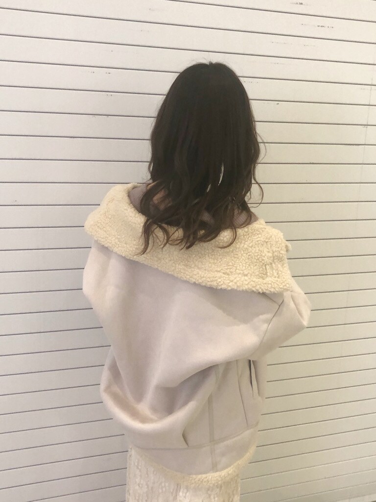 ブラウン系のブーツ、ホワイト系のスカート、ホワイト系のブルゾンを着用したレディースの冬コーディネートの4枚目の写真