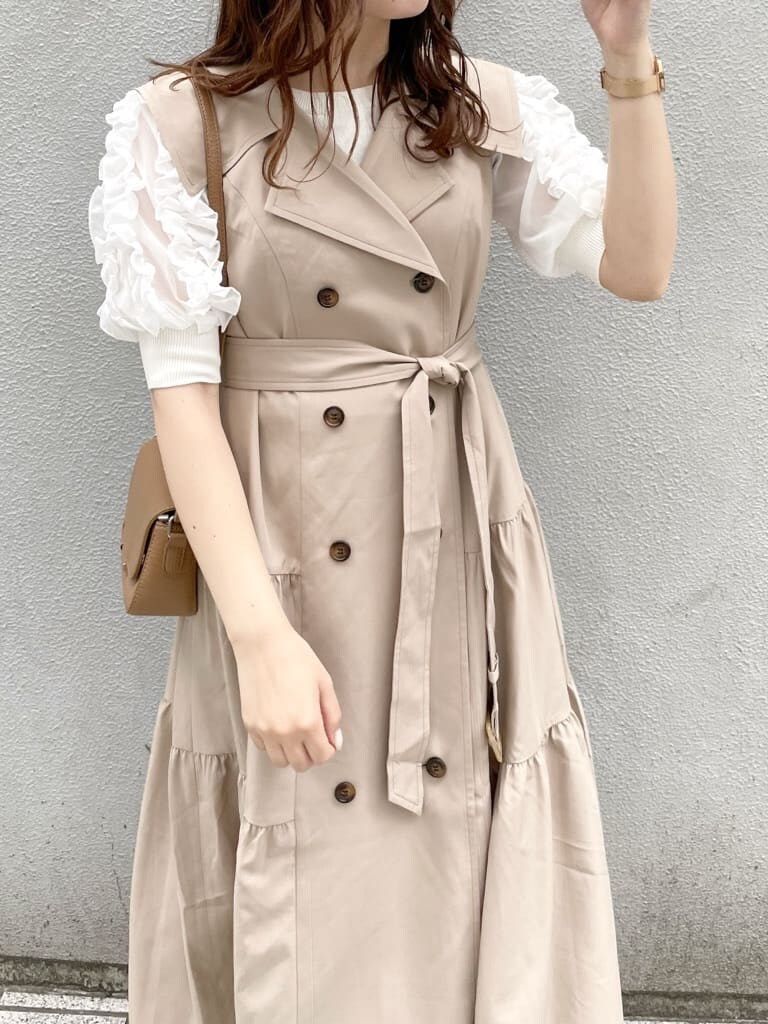 ベージュ系のワンピース、ホワイト系のパンプス、ブラウン系のショルダーバッグを着用したレディースの春コーディネートの5枚目の写真