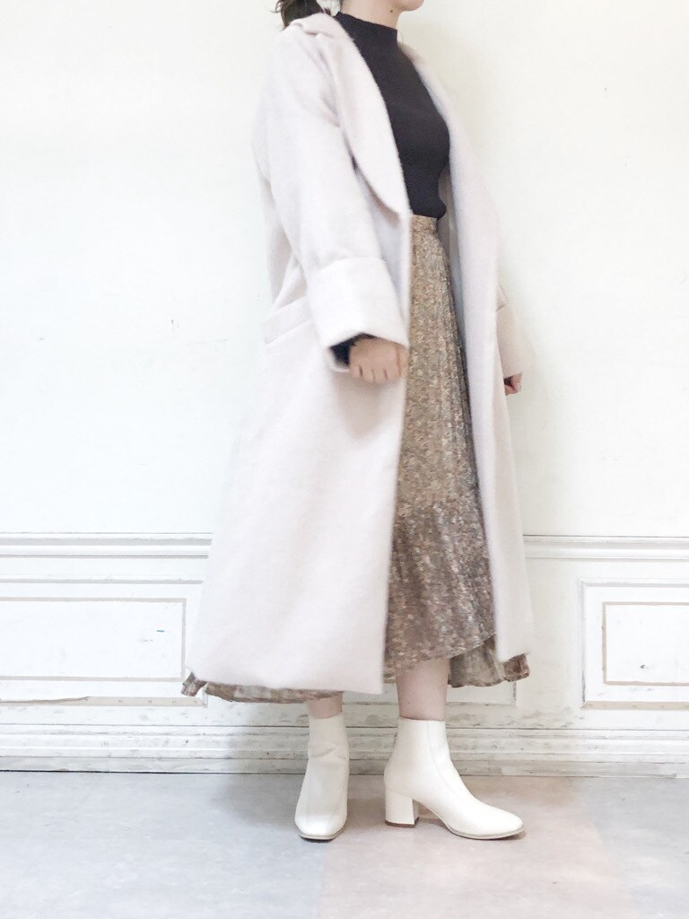ホワイト系のブーツ、ホワイト系のチェスターコート、ホワイト系のスカートを着用したレディースの秋コーディネートの4枚目の写真