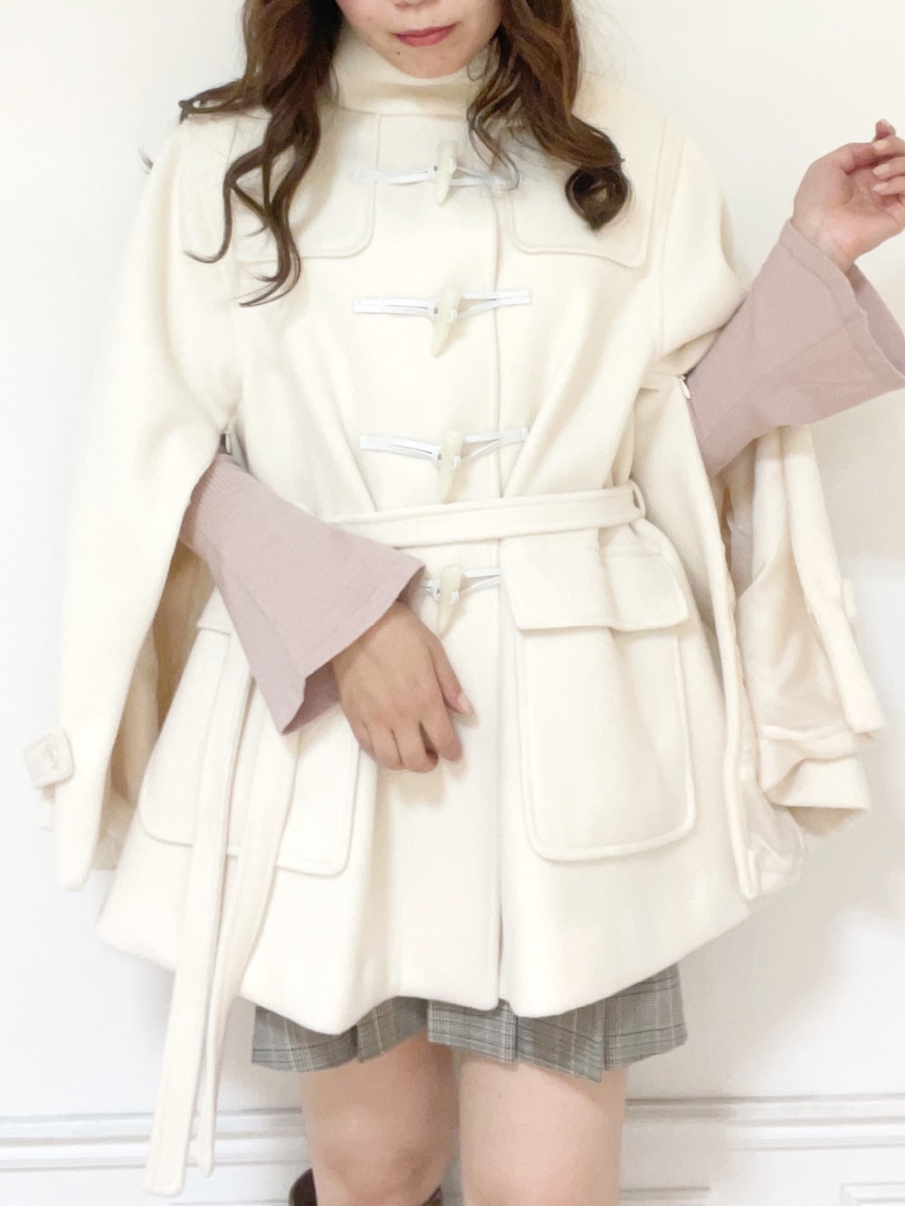 ホワイト系のダッフルコート、ピンク系のニット/セーター、その他のスカートを着用したレディースの秋コーディネートの4枚目の写真