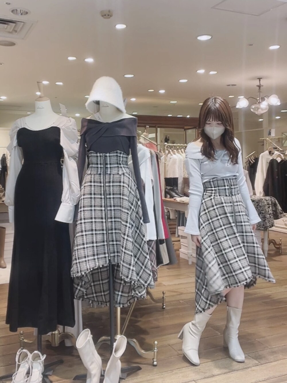 グレー系のニット/セーター、ブルー系のスカート、ホワイト系のブーツを着用したレディースの秋コーディネートの3枚目の写真