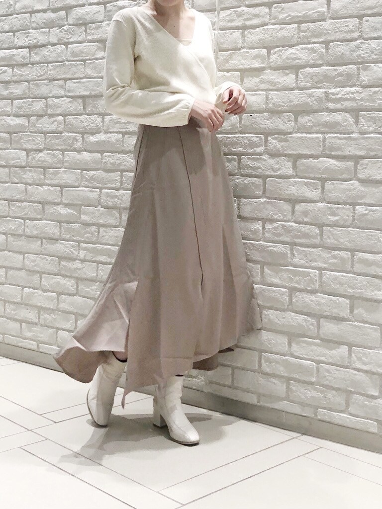 ホワイト系のブーツ、ベージュ系のスカート、ホワイト系のニット/セーターを着用したレディースの冬コーディネートの2枚目の写真