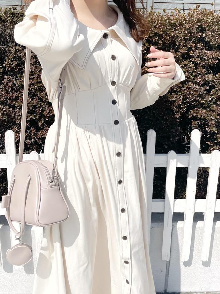 ホワイト系のワンピース、ホワイト系のパンプス、ベージュ系のハンドバッグを着用したレディースの春コーディネートの5枚目の写真