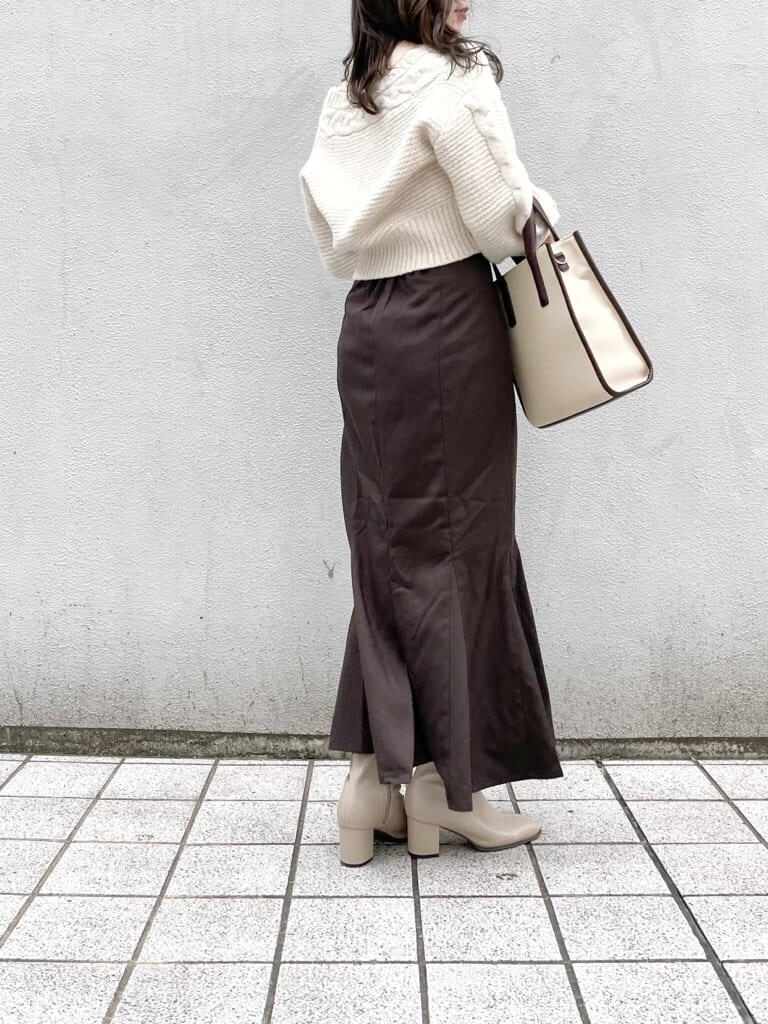 ホワイト系のカーディガン/ボレロ、ブラウン系のスカート、ベージュ系のブーツを着用したレディースの秋コーディネートの2枚目の写真