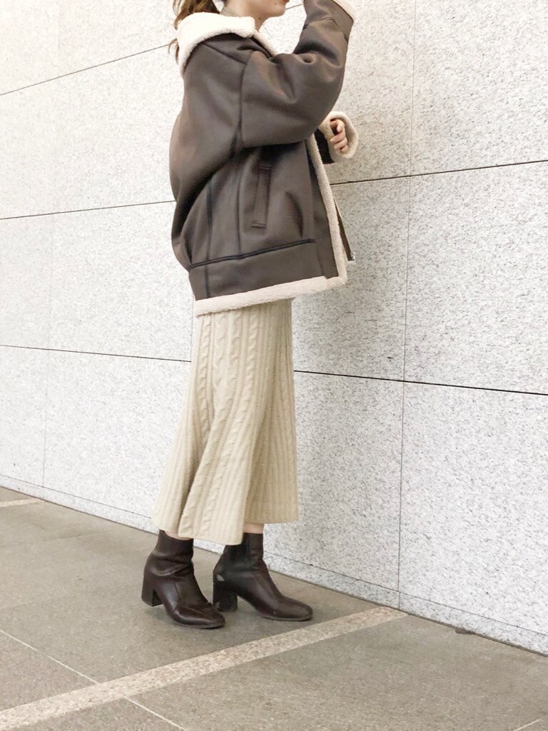 ブラウン系のブーツ、ブラウン系のブルゾン、ベージュ系のワンピースを着用したレディースの冬コーディネートの2枚目の写真