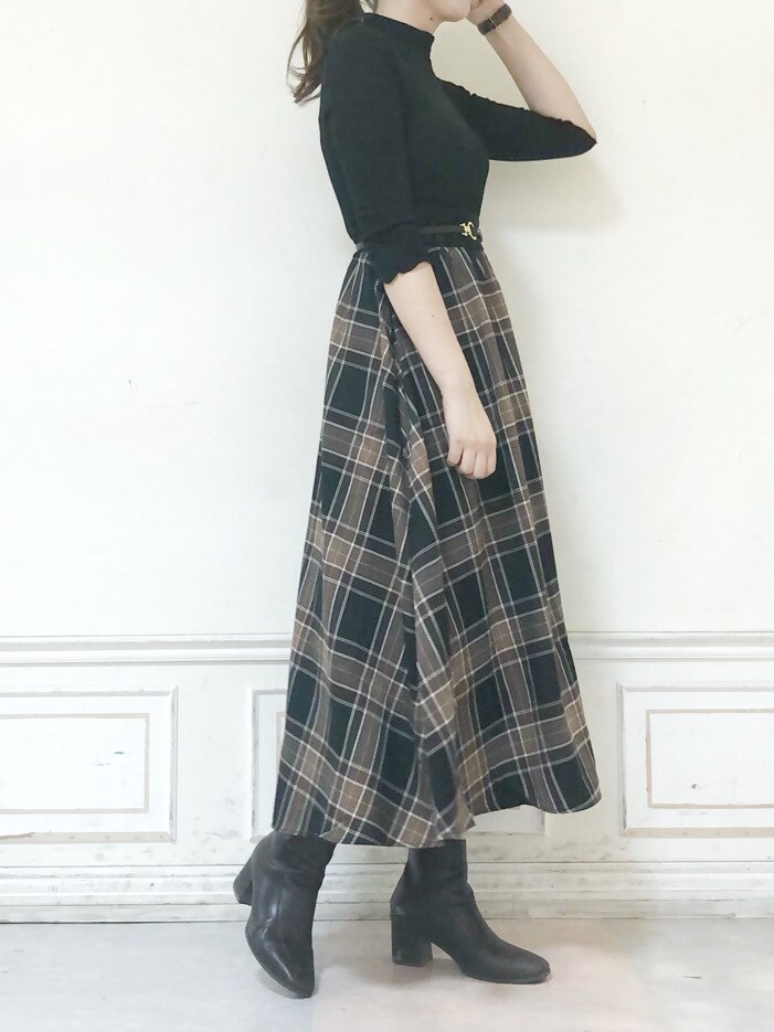 ブラウン系のブーツ、グリーン系のチェスターコート、ブラック系のワンピースを着用したレディースの秋コーディネートの6枚目の写真