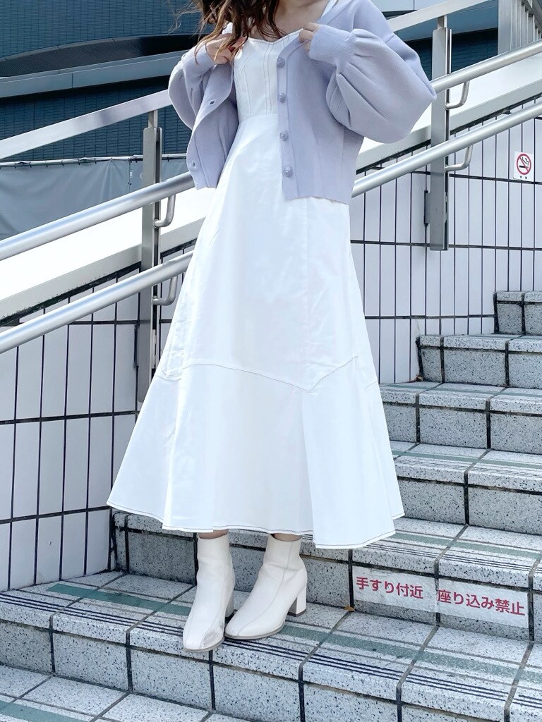 ホワイト系のブーツ、ホワイト系のワンピース、ブルー系のカーディガン/ボレロを着用したレディースの冬コーディネートの2枚目の写真