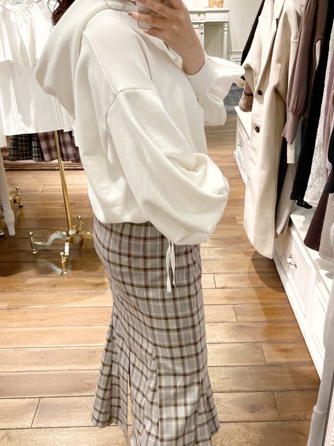 ホワイト系のその他シューズ、ホワイト系のパーカー、グレー系のスカートを着用したレディースの冬コーディネートの3枚目の写真