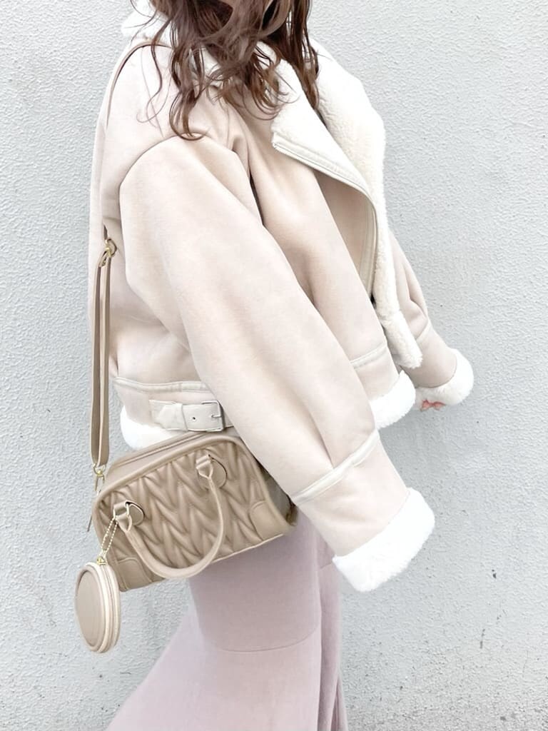 ホワイト系のブルゾン、ベージュ系のブーツ、ベージュ系のハンドバッグを着用したレディースの秋コーディネートの4枚目の写真