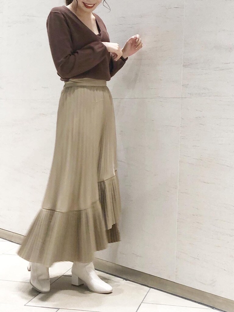 ホワイト系のブーツ、ベージュ系のスカート、ブラウン系のニット/セーターを着用したレディースの冬コーディネートの2枚目の写真