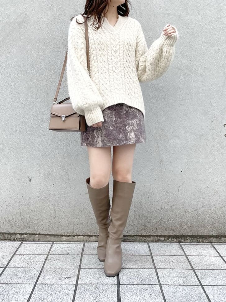 グレー系のスカート、ベージュ系のブーツ、ベージュ系のハンドバッグを着用したレディースの秋コーディネートの5枚目の写真