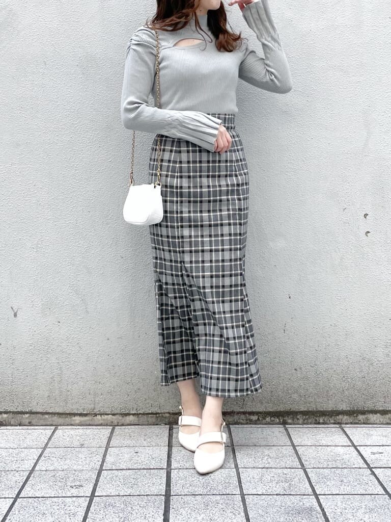 ベージュ系のトレンチコート、ブラック系のスカート、グリーン系のニット/セーターを着用したレディースの冬コーディネートの5枚目の写真