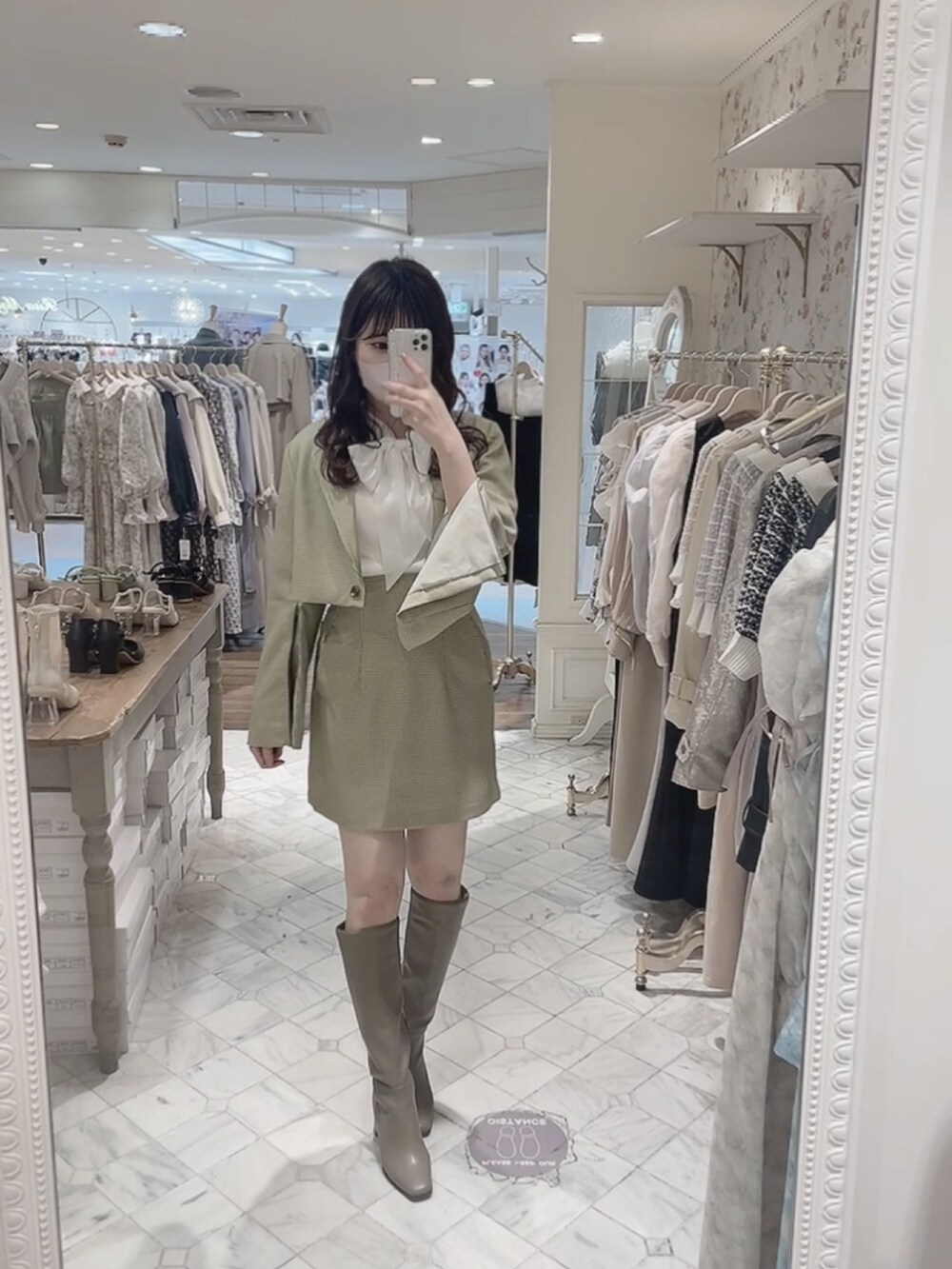 ホワイト系のニット/セーター、グリーン系のテーラードジャケット、グリーン系のスカートを着用したレディースの冬コーディネートの3枚目の写真