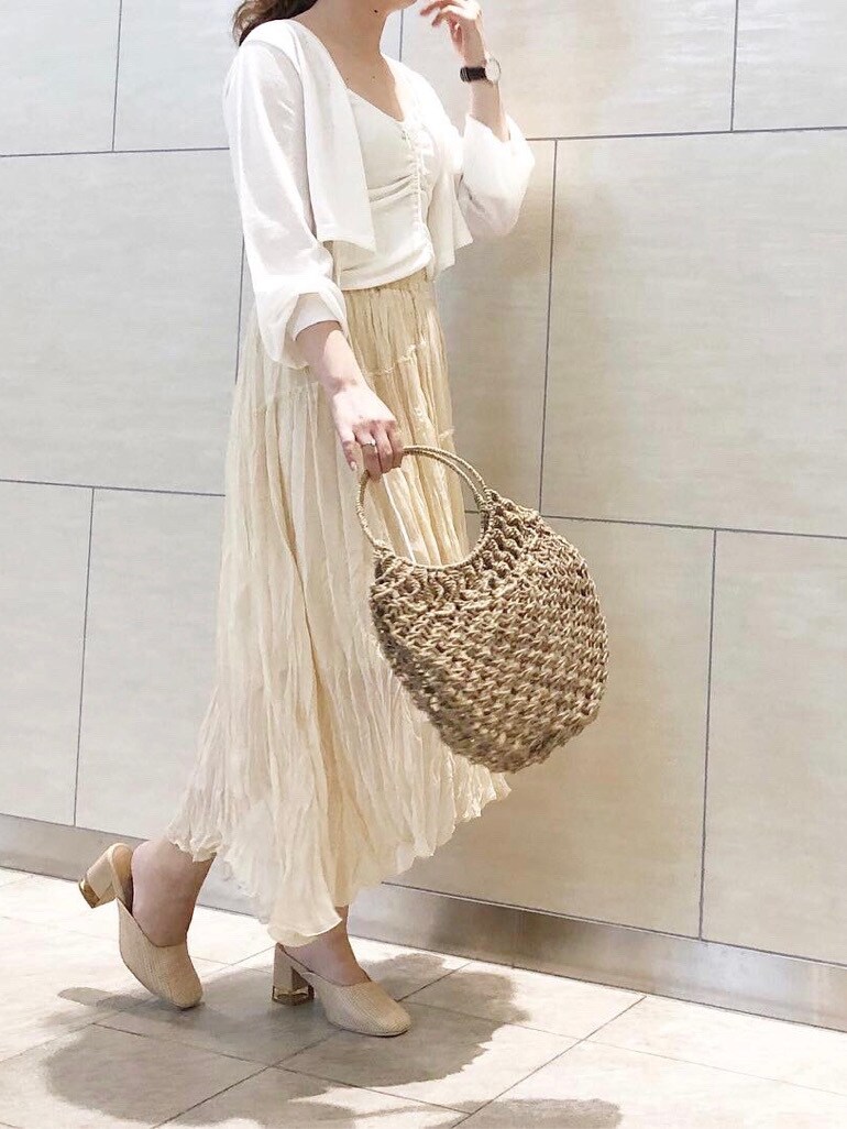 ホワイト系のスカート、ホワイト系のパンプス、ベージュ系のハンドバッグを着用したレディースの春コーディネートの3枚目の写真