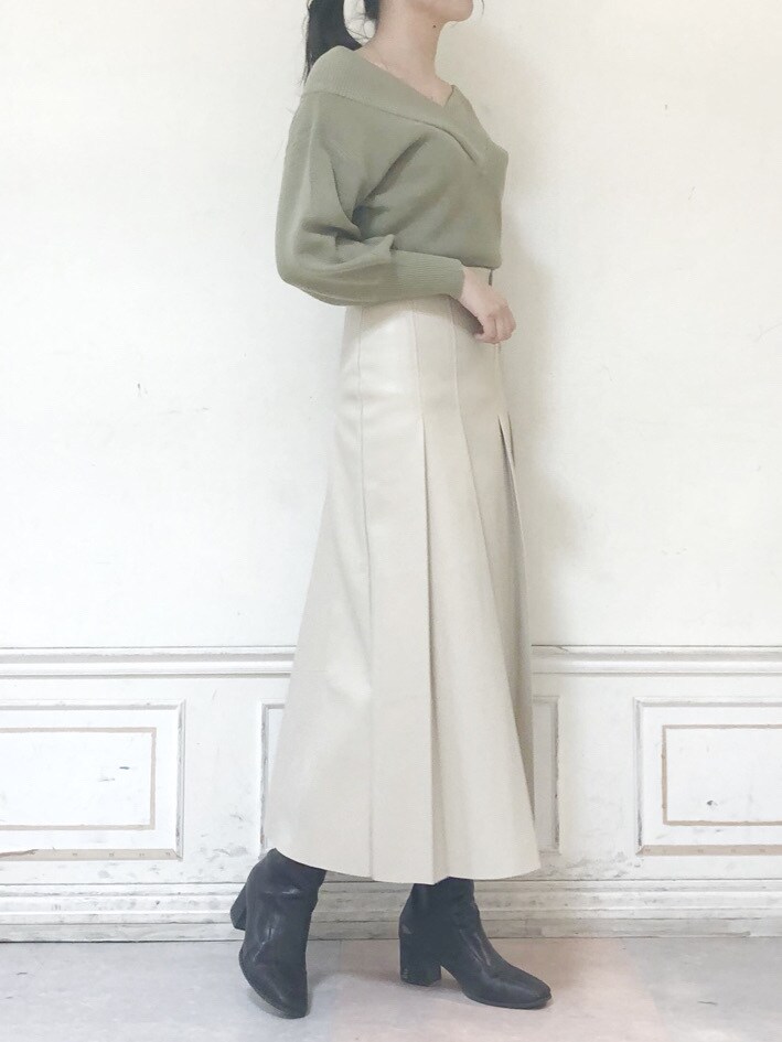 グリーン系のニット/セーター、ベージュ系のスカート、ブラウン系のブーツを着用したレディースの秋コーディネートの5枚目の写真