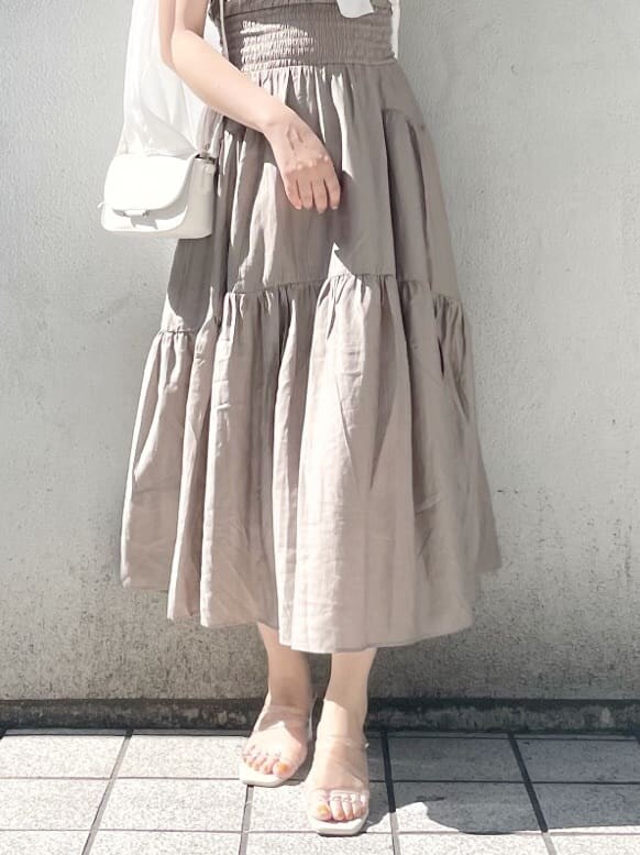 ホワイト系のショルダーバッグ、パープル系のサンダル、ベージュ系のワンピースを着用したレディースの春コーディネートの3枚目の写真