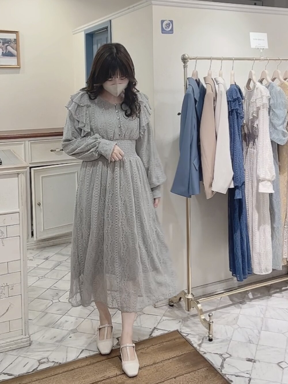 グリーン系のワンピース、ホワイト系のパンプスを着用したレディースの冬コーディネートの2枚目の写真