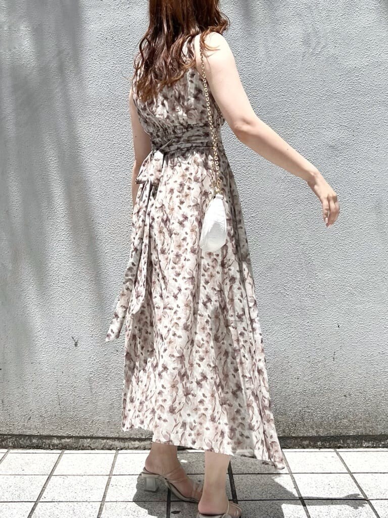 パープル系のサンダル、ベージュ系のワンピースを着用したレディースの夏コーディネートの2枚目の写真