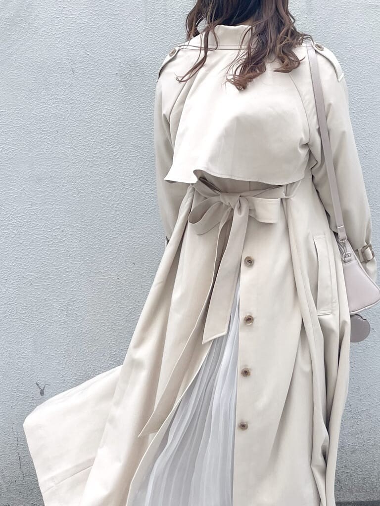 ベージュ系のトレンチコート、ピンク系のワンピース、ホワイト系のパンプスを着用したレディースの春コーディネートの5枚目の写真